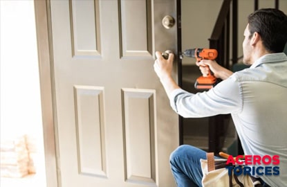 Hombre instalando una cerradura de tipo tubular en su puerta