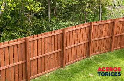 Una cerca para jardín fabricada con madera y pintada en color marrón