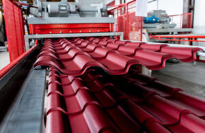 Láminas tipo teja metálicas saliendo de roladora industrial