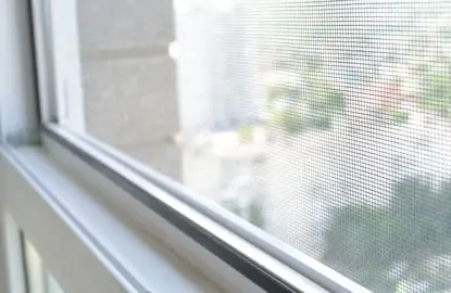 Close up a una ventana con protección de malla mosquitera